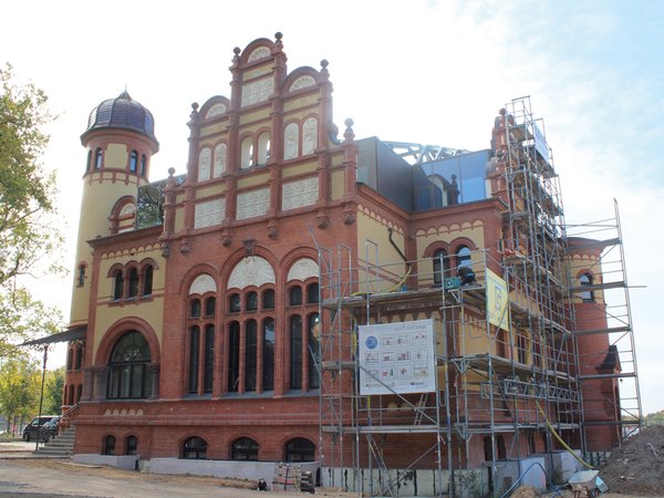 Eine Stadtansicht der Landeshauptstadt Schwerin mit historischer Architektur am Wasser, in warmen Erdtönen unter klarem Himmel